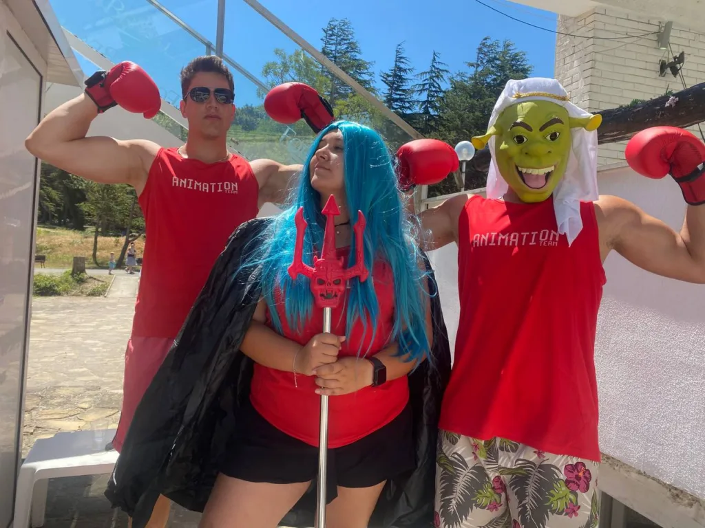 Аниматори с боксови ръкавици, синя перука и маска на Шрек позират на тераса
